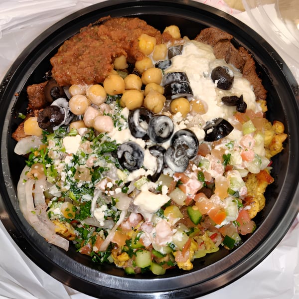 A Hala's Grill halal bowl with falafel, chickpeas, olives, salad, and white sauce.