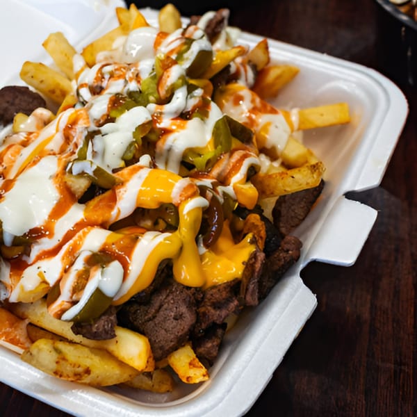 Hala's Grill halal fries topped with meat, cheese sauce, white sauce, and hot sauce.
